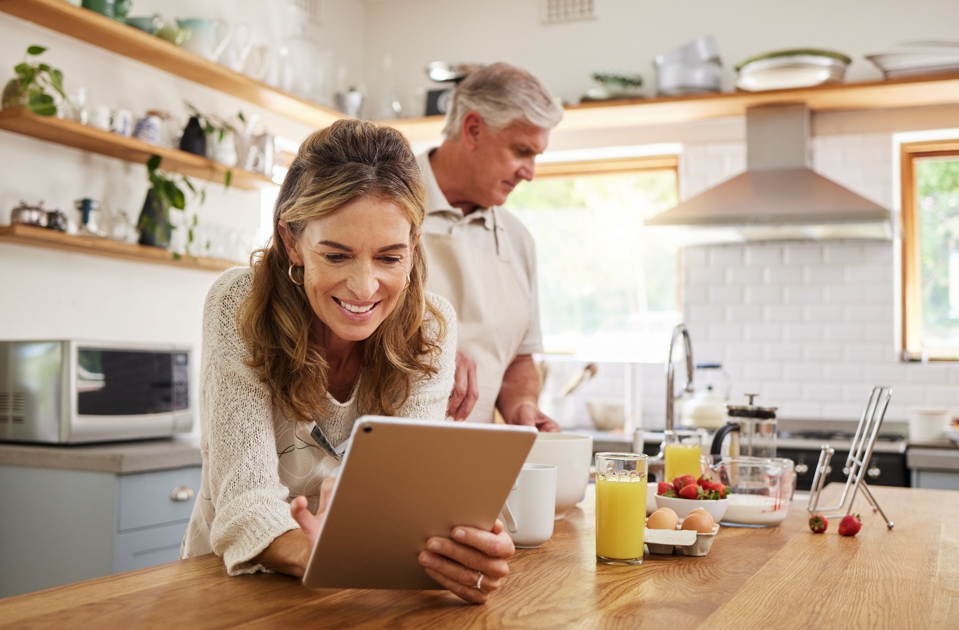 Woman, tablet and old couple in home kitchen on social media, internet surfing or reading news. Retirement, elderly husband and wife in house with 5g mobile and streaming web content on digital tech.
